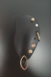 14ct gold Marquise Slice Earring, Mini Flat-head, Cross-head screw earrings, 12mm sleeper hoop, silver circle labret and 4mm gold ball ear stack on a black magnetic ear