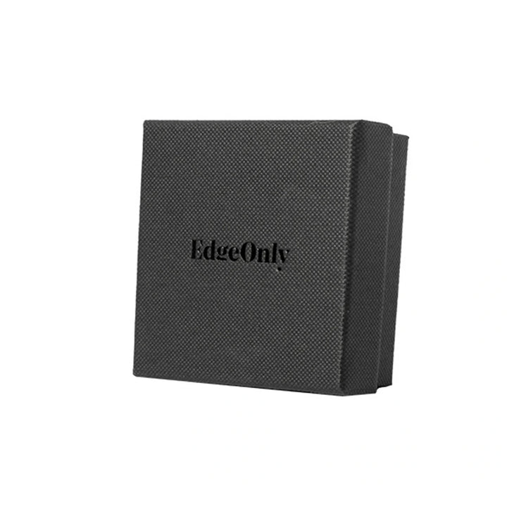 A textured black square box with the brand name &